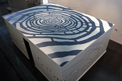 blue labyrinth on top of a built room inside a gallery