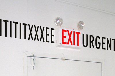 exit sign with black letters to the left reading: "ITITXXEE" and to the right reading "URGE"