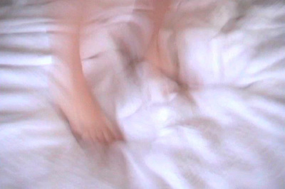 feet in motion, seem to be jumping on a bed