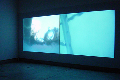 two projected images (blue and cyan color) on dark wall